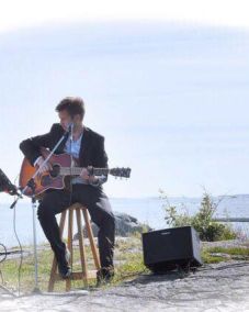 En person som spelar gitarr och sjunger